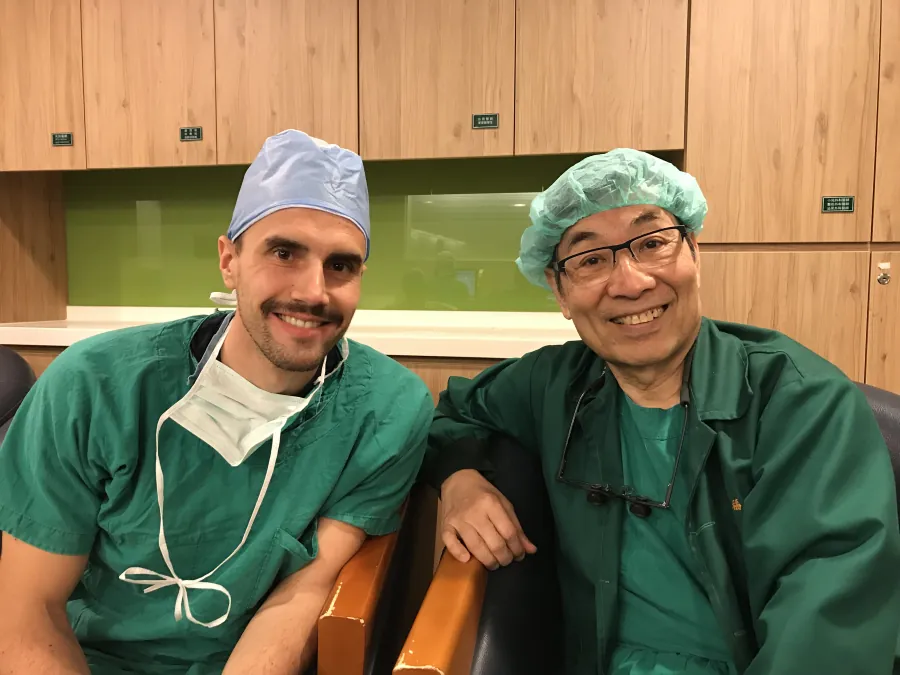 Il Dr. Guido Gabriele in divisa da sala verde, seduto accanto a un collega