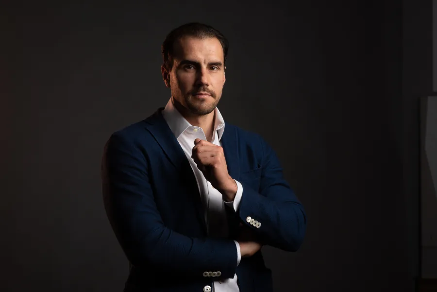 Il Dr. Guido Gabriele in giacca blu, con la mano vicino al mento, ritratto su fondo scuro